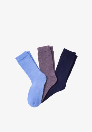 Trois paires de chaussettes plates mi-mollet en bleu clair, gris et bleu marine foncé, disposées en chevauchement sur un fond blanc.