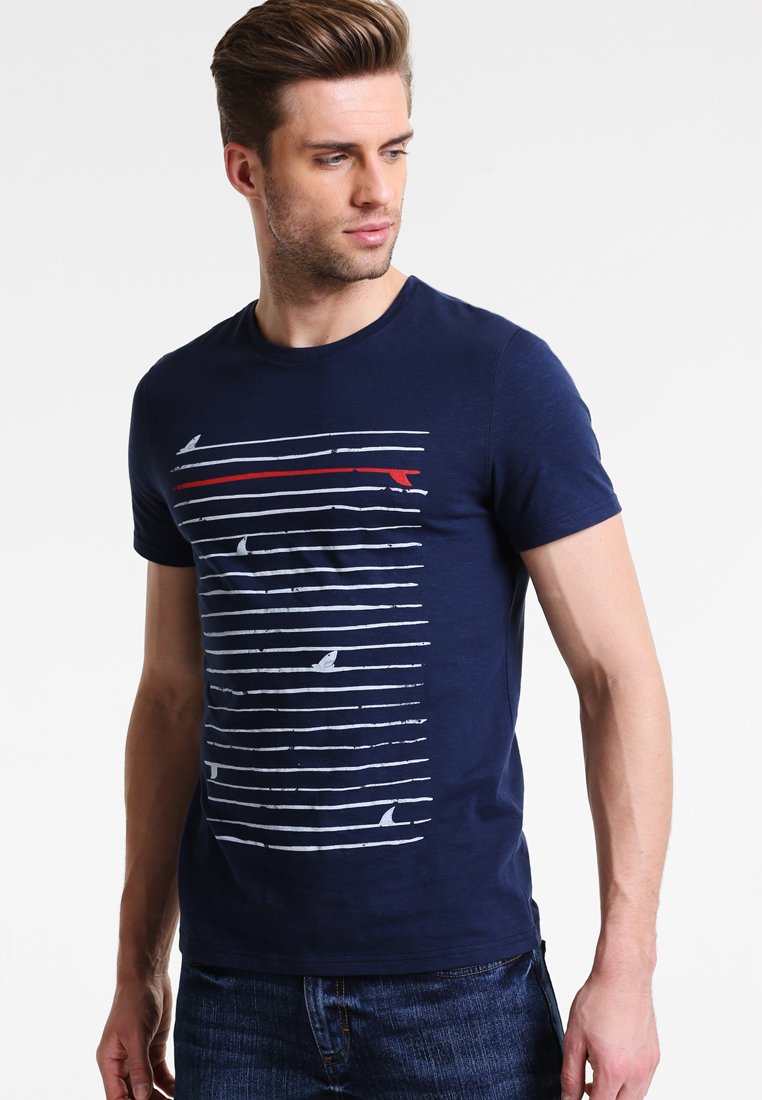 Navy blue cotton t-shirt featuring horizontal white and red stripes with ocean-themed graphics. Casual crew neck and short sleeves.