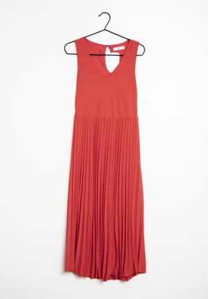 Robe maxi rouge sans manches avec col en V et jupe plissée suspendue sur un cintre noir sur fond blanc.