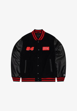 Must ülikooliteemaline jakk punase ja musta triibulise soonikkoeluse krae ja mansettidega. Omab nahkvarrukad, tikitud logo ja paelaga kinnitust.