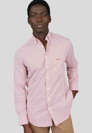 Chemise à boutons en motif pois rouge et blanc, fabriquée en tissu léger, dotée d'un col classique et de manches longues.