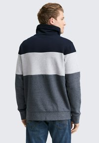 Herren-Sweatshirt mit hohem Kragen, ausgestattet mit horizontalen Streifen in Marineblau, Grau und Dunkelgrau. Hergestellt aus einem weichen, strukturierten Stoff.