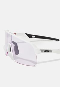Gafas de sol blancas con una gran lente plana de tonalidad rosa, acentos negros en las varillas y hardware plateado texturizado en las patillas.