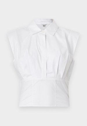 Bluza albă fără mâneci, cu guler și nasturi ascunși în față, cu detaliu de talie croită, prezentată pe un fundal simplu.