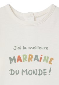 Weißer Baumwoll-Overall mit mehrfarbigem Text, der "J'ai la meilleure MARRAINE DU MONDE!" in verschiedenen Schriftarten und Größen zeigt.
