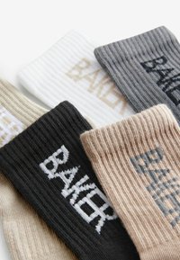 Set bestehend aus fünf gerippten Socken in verschiedenen Farben (schwarz, beige, weiß, grau). Jede Socke trägt das Wort "BAKER" in kontrastierenden Farben.