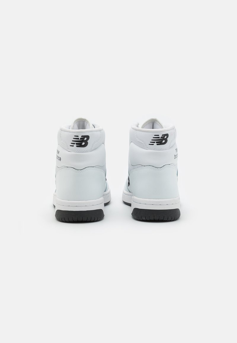 Sneakers alte bianche con esterno in pelle liscia, dettagli neri del logo e suola in gomma testurizzata. Design semplice e colletto imbottito.