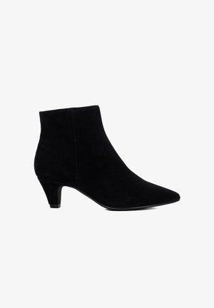 Bottine en suède noir avec un bout pointu et un petit talon kitten, vue de profil sur fond blanc.