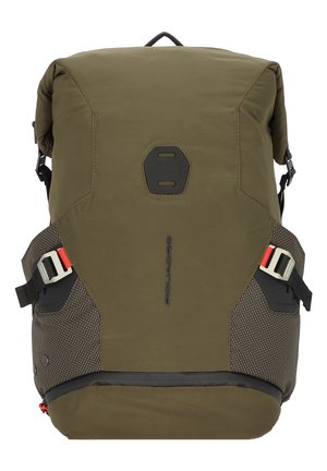 Zaino verde oliva con design a roll-top, dettagli testurizzati, tasche laterali in rete e spallacci regolabili. Presenta un dettaglio centrale con logo.