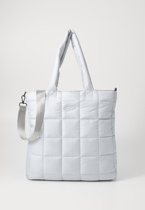 Light gray quilted tote bag with two padded handles and an adjustable shoulder strap hanging against a plain background.