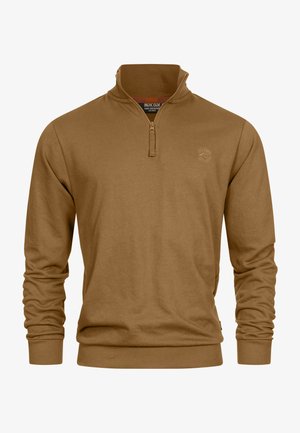 Sudadera marrón con cremallera, hecha de un tejido suave. Presenta un cuello alto, mangas largas y puños de canalé. Detalle sutil del logo en el pecho.