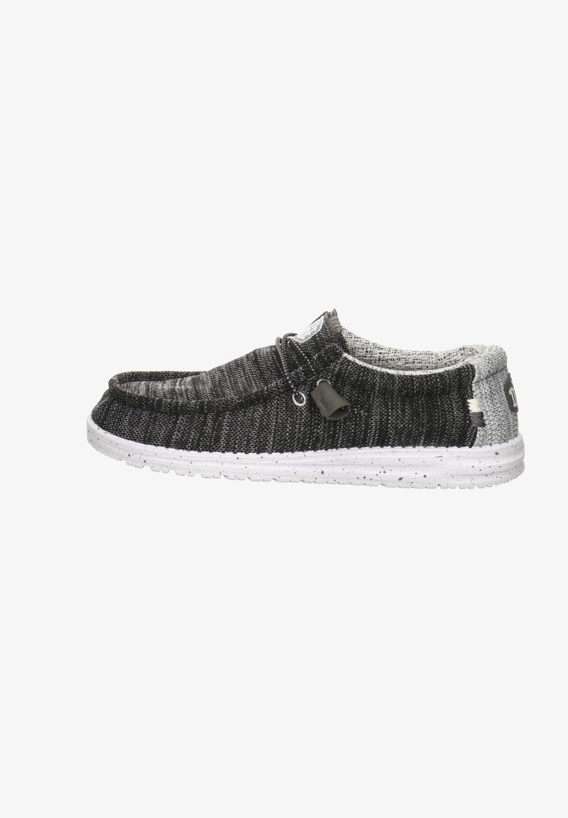 Black and grey fabric slip-on shoe with a white speckled sole, featuring a textured upper and simple lace detail.