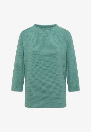 Turkos långärmad topp med ett strukturerat, honungskaksmönster och hög krage. Tyget har ett ventilerande, mjukt utseende.