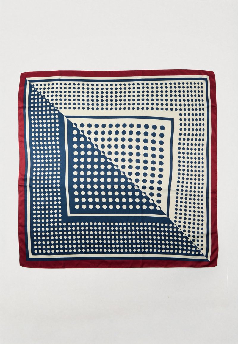 Zīda kvadrātveida šalle ar tumši zilu un krēmkrāsas polka punktu rakstu, apmale tumši sarkanā krāsā, aptuveni 90 cm x 90 cm izmērā.