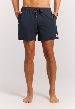 Shorts de bain bleu marine avec une taille élastique, un cordon de serrage, un tissu texturé, deux poches latérales et une petite étiquette de marque sur l'ourlet.