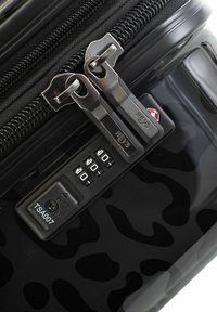 Schwarzer Hartschalenkoffer mit glänzendem Leopardenmuster, zwei silbernen Reißverschlüssen und einem TSA-zugelassenen Kombinationsschloss mit einem 3-stelligen Drehknopf.