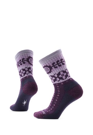 Par de calcetines de lana con estampado morado y lavanda de pie sobre fondo blanco.