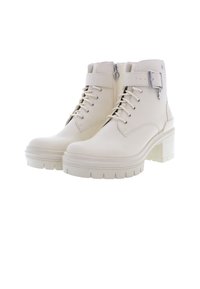Stivaletti beige fino alla caviglia realizzati in pelle liscia, con tacco a blocco alto, chiusura con lacci sul davanti, zip laterale e dettaglio con fibbia in metallo.