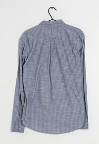 Chemise à manches longues à carreaux bleu et blanc. Fabriquée en tissu léger, elle présente un col boutonné et un détail de pli au dos.