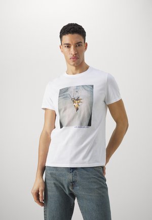 Hvid bomulds T-shirt med et fotografisk print af denim og et vedhæng, med teksten "LOS ANGELES, 2017" nederst. Casual design.