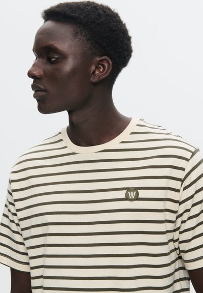 Striped T-shirt with a cream base and olive green horizontal stripes. Features a small embroidered logo on the chest. Cotton material.
