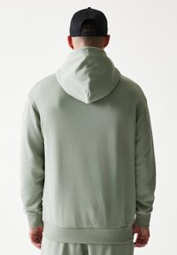 Φούτερ με κουκούλα σε ανοιχτό πράσινο χρώμα, κατασκευασμένο από μαλακό ύφασμα. Διαθέτει άνετη εφαρμογή, ριμπ μανσέτες και τελείωμα, με κουκούλα που ρυθμίζεται με κορδόνι.