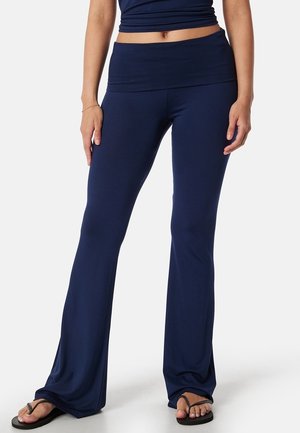 Middengrijze flared yogapants van rekbare, zachte stof met een brede tailleband en een gladde textuur, met een aansluitend ontwerp.