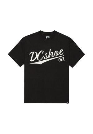 Mustavilla T-paita, joka on valmistettu puuvillasta ja jossa on iso valkoinen logo "DCshoe Co." edessä. Normaali malli, jossa on lyhyet hihat.