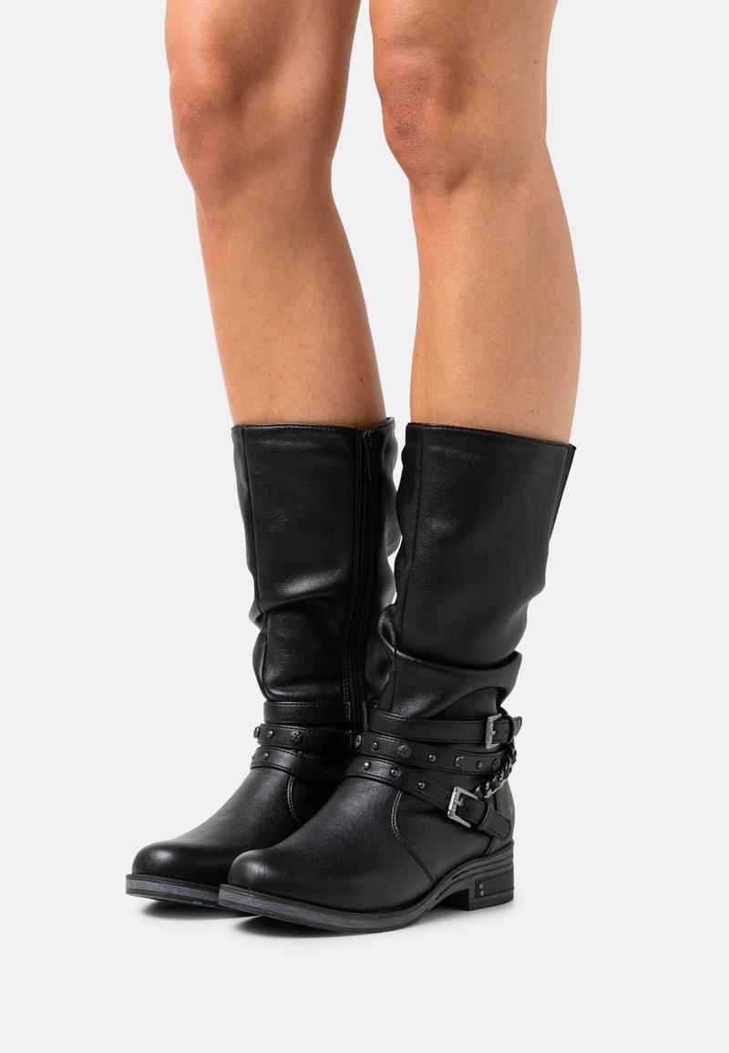 Schwarze Lederkniehohe Stiefel mit einem lässigen Design, silbernen Nietenakzenten und einem seitlichen Reißverschluss. Niedriger Blockabsatz für Stabilität.