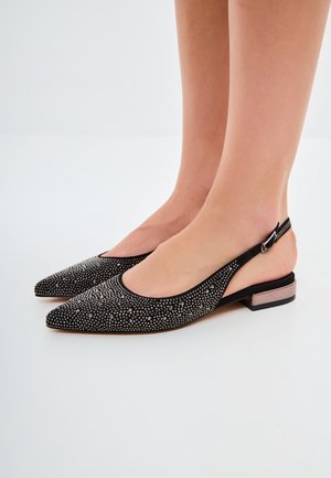 Scarpe slingback nere con punta affusolata, decorate con borchie argentate, dotate di un tacco basso e di una texture morbida.