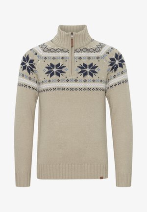 Pull en maille beige avec un col zippé mi-hauteur, présentant un motif de flocon de neige en bleu marine et bleu sur la poitrine, ainsi qu'un ourlet et des poignets côtelés.
