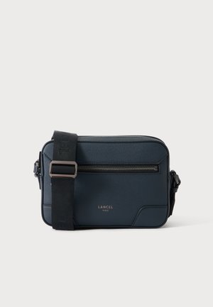 Donkerblauwe rechthoekige leren crossbodytas met zwarte verstelbare riem en voorvak met rits, gebrandmerkt Lancel Paris in gouden letters.