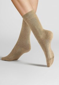 Beige ankle socks with a smooth texture, ribbed cuff, and reinforced heel. Displayed in a side angle against a light background.