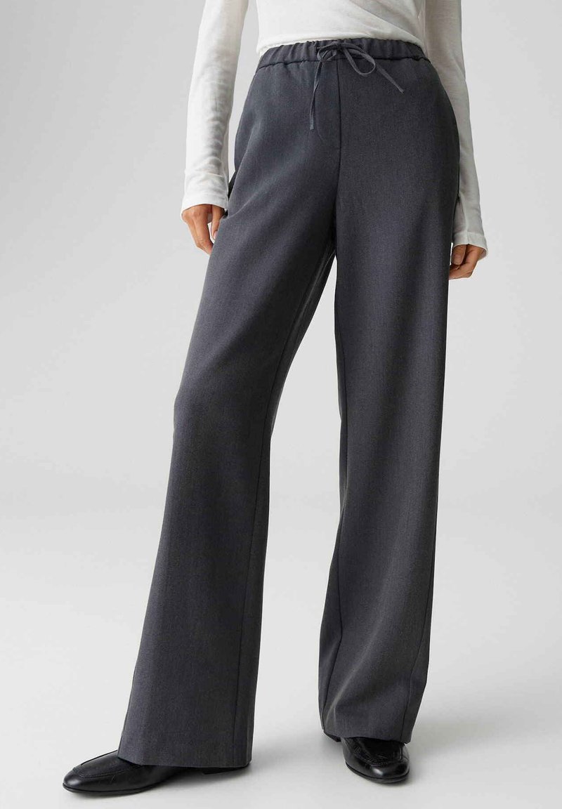 Grijze broek met wijde pijpen, gemaakt van een zachte stof, voorzien van een elastische tailleband met trekkoord. Glad oppervlak en een nauwsluitende pasvorm.