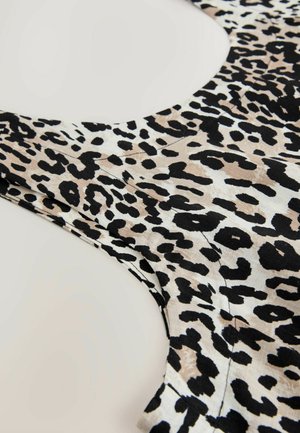 Top cu imprimeu de leopard, cu guler rotund, dintr-un material ușor, cu pete bej, negre și maro și detalii de cusătură vizibile.