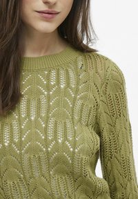 Sweter dzianinowy w oliwkowej zieleni z fakturowanym wzorem liści, z detalami ażurowymi i prążkowanym dekoltem okrągłym.
