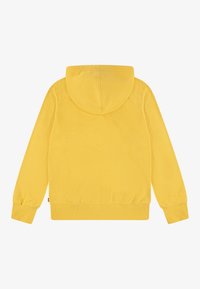 Gul sweatshirt med hette, ribbede mansjetter og linning. Glatt tekstur med en ensfarget overflate, uten synlige mønstre eller detaljer.