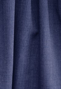 Granatowa tkanina teksturowa z drobnym wzorem siatki, prezentująca miękkie marszczenia i lekko błyszczące wykończenie.