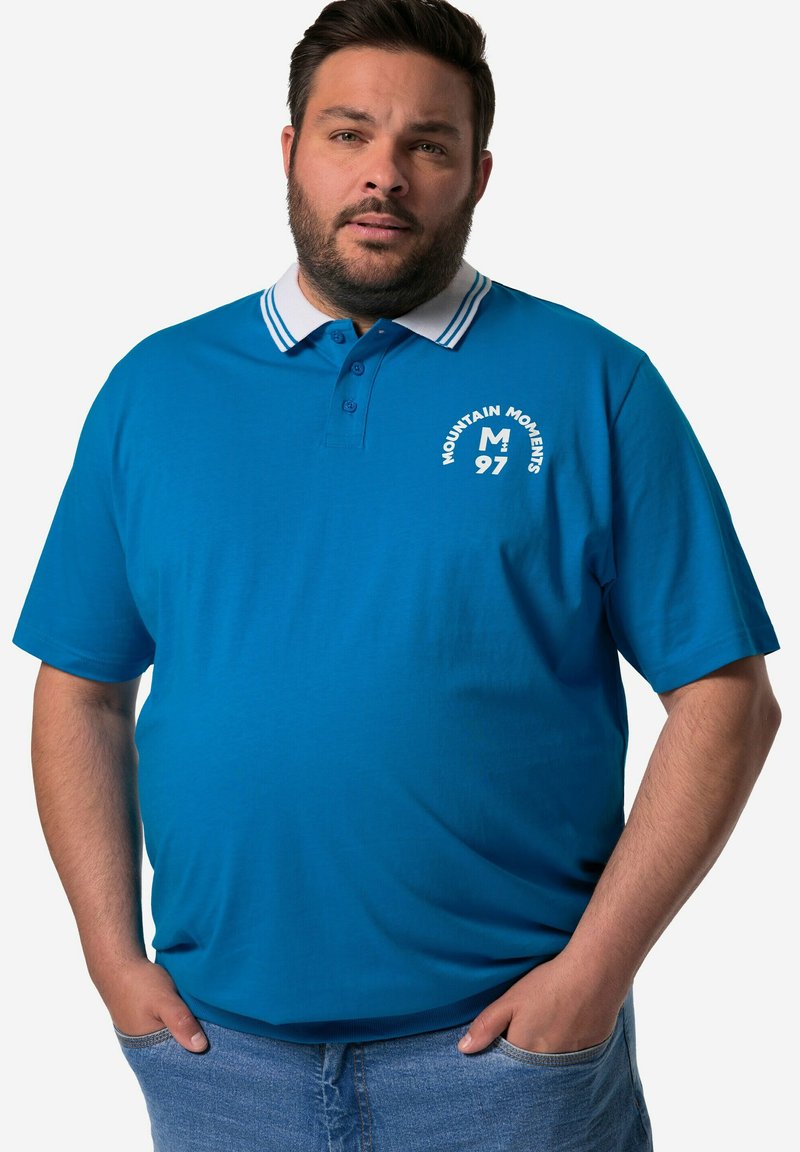 Modrá polo košile s bílým pruhovaným límcem, předními knoflíky a potiskem loga. Vyrobena z bavlny, má krátké rukávy a volný st�řih.