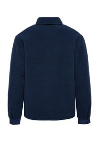 Marinblå fleecejacka med en mjuk, texturerad yta, långa ärmar och krage. Har manschetter vid ärmarna och en avslappnad passform.