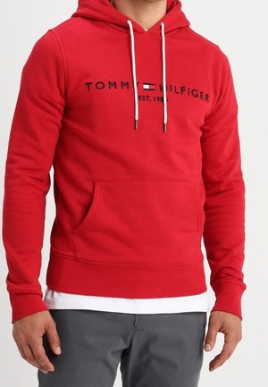Red hoodie made of cotton blend with drawstrings, a front pocket, and printed brand logo in dark navy. Casual fit with ribbed cuffs.