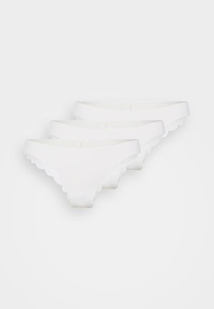 Tři bílé dámské bikinové kalhotky s krajkovým lemem, naskládány diagonálně na čistě bílém pozadí.