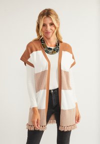 Pletený cardigan s hnědým a bílým barevným blokem a vzorem herringbone. Rozšířené rukávy a detail s třásněmi na spodním lemu.