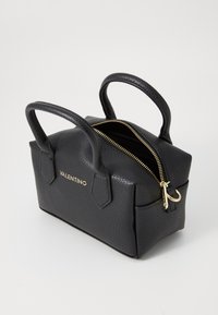 Majhna črna usnjena torbica z teksturirano površino, zlatim zadrgo, dvema zaobljenima ročajema in embosiranim logotipom "Valentino" na sprednji strani.