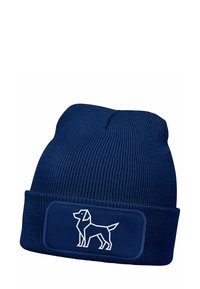 Navy blue knitted beanie with a folded cuff. Features a contrasting white graphic of a dog on a rectangular patch. Soft texture.