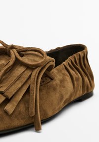 Brown suede ballet flats with a fringed upper and bow detail. Gathered sides and smooth interior. Flat sole for comfortable wear.