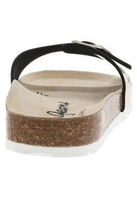 Zwarte flip-flop sandaal met een kurken voetbed, een getextureerde beige binnenzool en een witte rubberen buitenzool. Kenmerkt zich door een strakke zwarte bandontwerp.