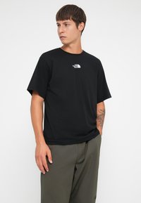 Sort kortærmet t-shirt lavet af bomuld, med et hvidt logo på venstre bryst. Designet er enkelt med en rund halsudskæring.