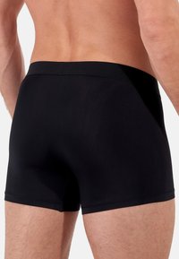 Black boxer briefs with a smooth, stretchy fabric and a soft waistband, designed for comfort and minimal seams.
