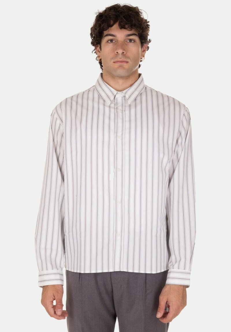 Camicia bianca a maniche lunghe con righe verticali viola, chiusura con bottoni, colletto classico e taglio dritto. Tessuto morbido con una texture liscia.
